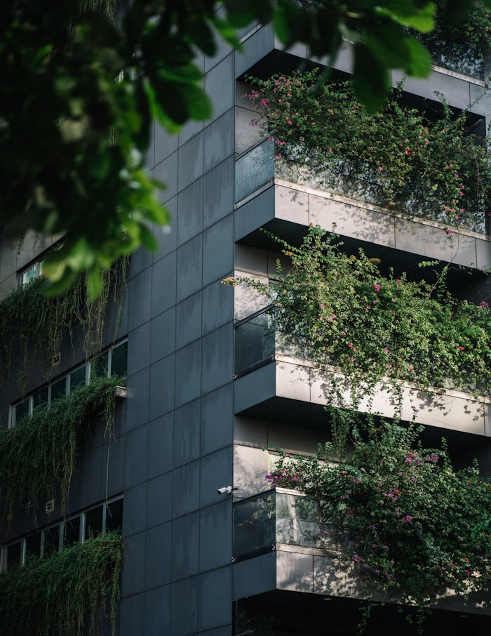 Contemporary building featuring lush vertical gardens on balconies.